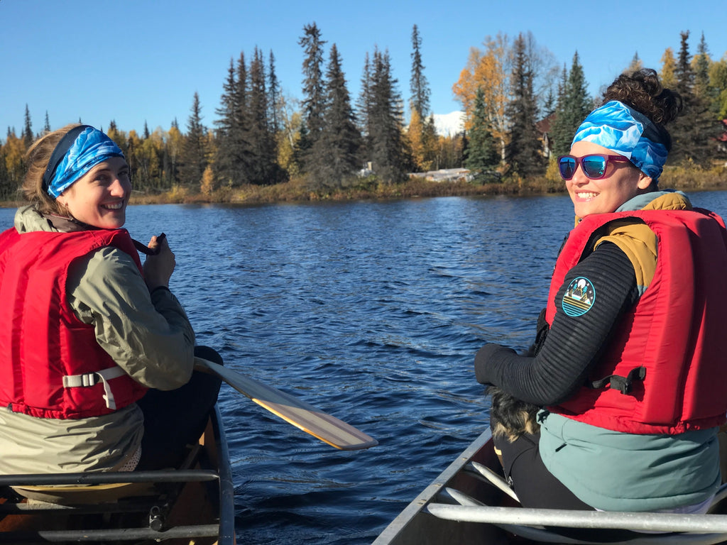 Sarah and Katrina canoeing side by side in matching Turnagain Pass buffs